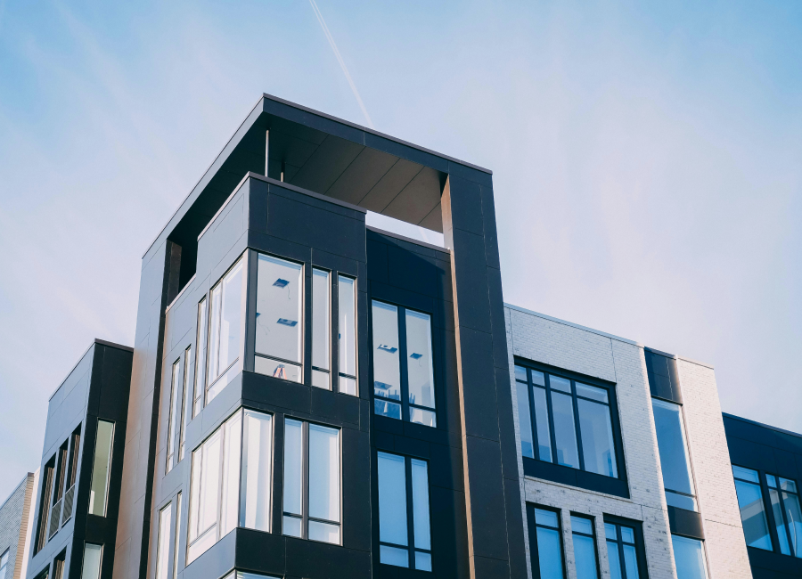 A contemporary multi-story apartment building featuring modern design and large windows.